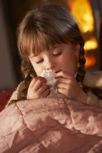 Sairas tyttö kylmä lepää sohvalla mukavalla hirsipalolla — kuvapankkivalokuva