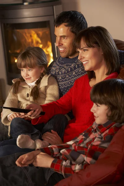Familia relajante ver la televisión por acogedor registro de fuego —  Fotos de Stock