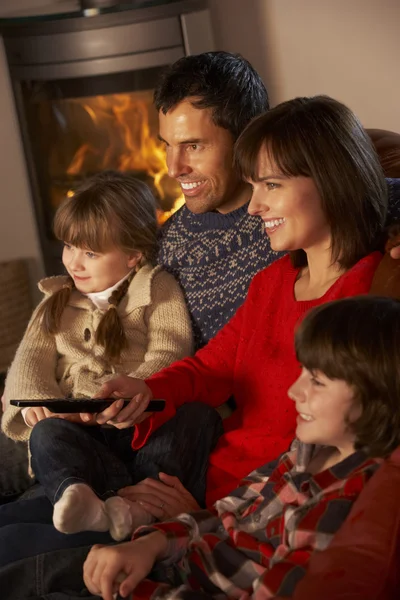 Familie ontspannen tv kijken door gezellige open haard — Stockfoto