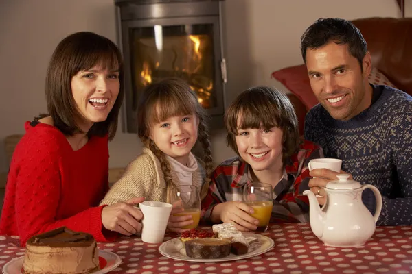 Ritratto di famiglia godendo tè e torta da accogliente Log Fire — Foto Stock