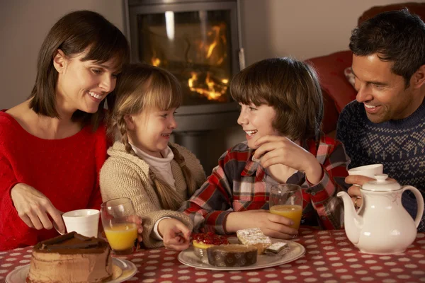 居心地の良い暖炉でお茶とケーキを楽しむ家族の肖像画 — ストック写真