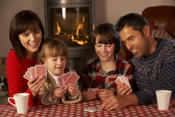 Retrato de família jogando cartas por acolhedor fogo Log — Fotografia de Stock