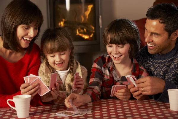 Retrato de la familia jugando a las cartas por fuego de registro acogedor —  Fotos de Stock