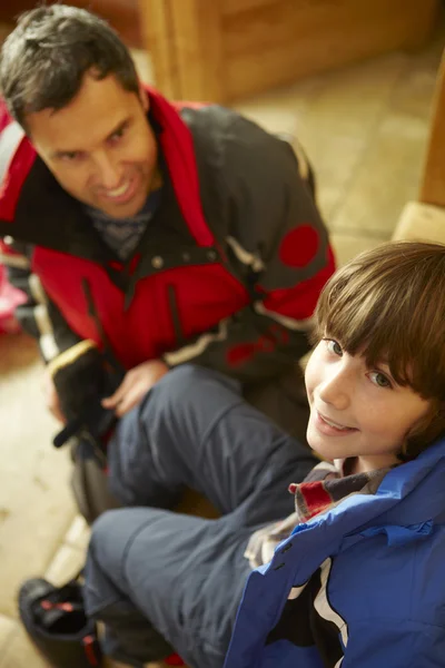 Vater hilft Sohn, warme Outdoor-Kleidung und Stiefel anzuziehen — Stockfoto