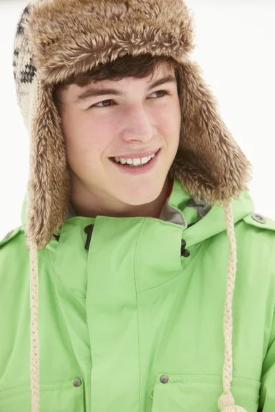 Karda kürk şapka giyen genç çocuk portresi — Stok fotoğraf