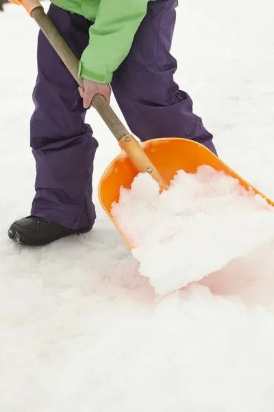 Nahaufnahme eines halbwüchsigen Jungen, der Schnee vom Weg schaufelt — Stockfoto