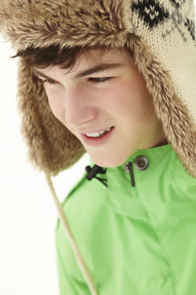 毛皮の帽子を着て雪の 10 代の少年のポートレート — ストック写真