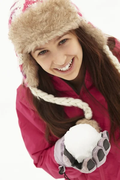 Tienermeisje houden sneeuwbal het dragen van bont hoed — Stockfoto