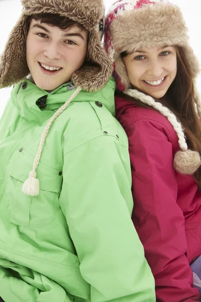 Porträtt av tonåriga par i snö bär päls hattar — Stockfoto