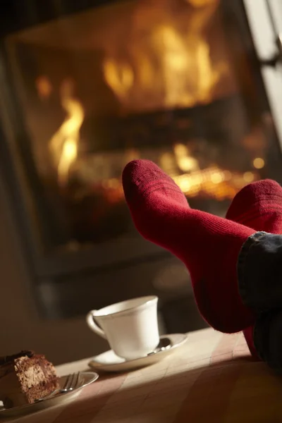Close Up di Mans piedi rilassante da accogliente log fuoco con tè e Cak — Foto Stock