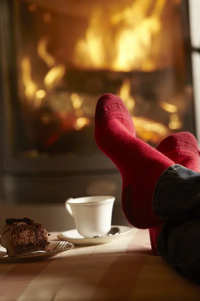Close Up di Mans piedi rilassante da accogliente log fuoco con tè e Cak — Foto Stock