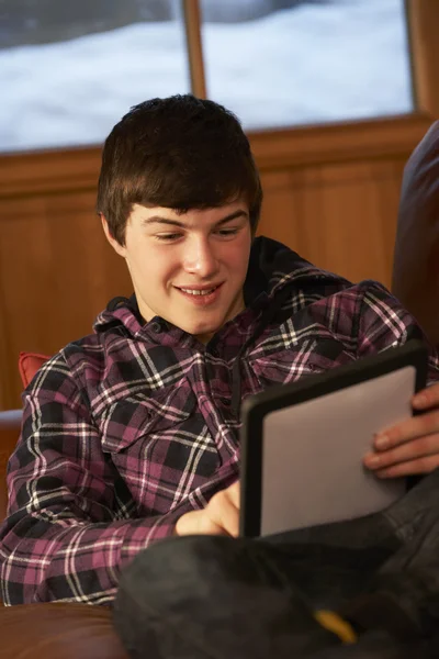 Adolescente menino relaxante no sofá com tablet computador — Fotografia de Stock