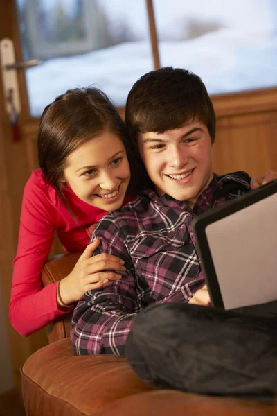 10 代のカップルがタブレット コンピューターが付いているソファーでリラックス — ストック写真