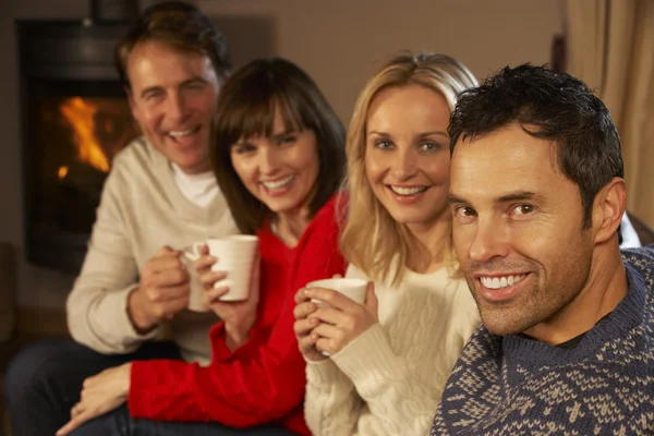 Grupo de parejas de mediana edad sentadas en un sofá con bebidas calientes Tal — Foto de Stock