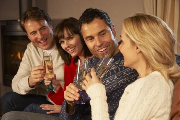 Skupina středního věku páry sedí na pohovce se šampaňským — Stock fotografie