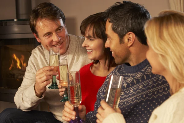 Gruppe von Paaren mittleren Alters sitzt auf Sofa mit Champagner — Stockfoto