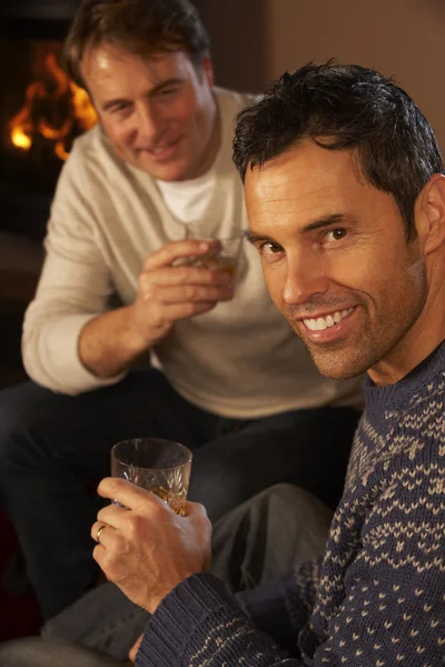 Two Middle Aged Men Relaxing Sitting On Sofa Drinking Whisky — Stock Photo, Image