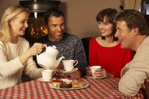 Grupo de casais de meia-idade desfrutando de chá e bolo juntos — Fotografia de Stock