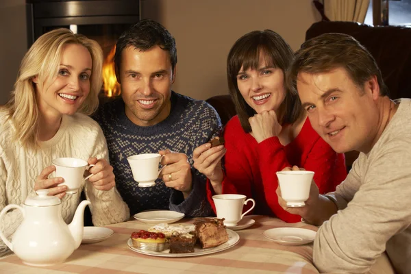 Grupo de parejas de mediana edad disfrutando del té y la torta juntos — Foto de Stock