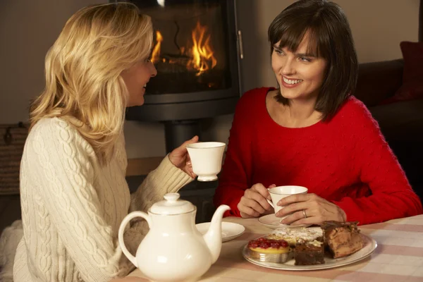 Två medelålders kvinnor njuter av te och kaka tillsammans — Stockfoto