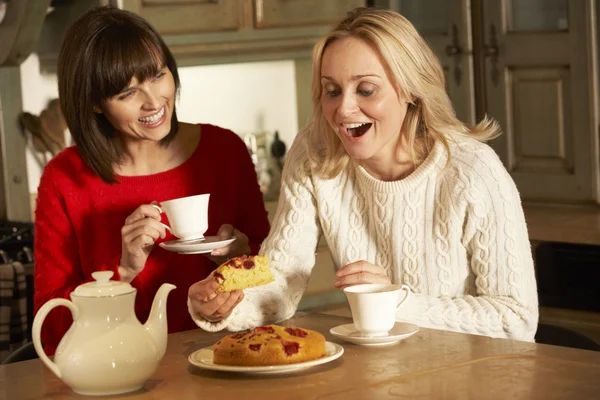 Dvě ženy středního věku, těší čaj a zákusek společně — Stock fotografie