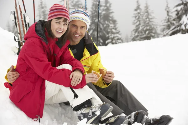 Couple moyen-âge manger Sandwich sur les vacances de ski dans les montagnes — Photo