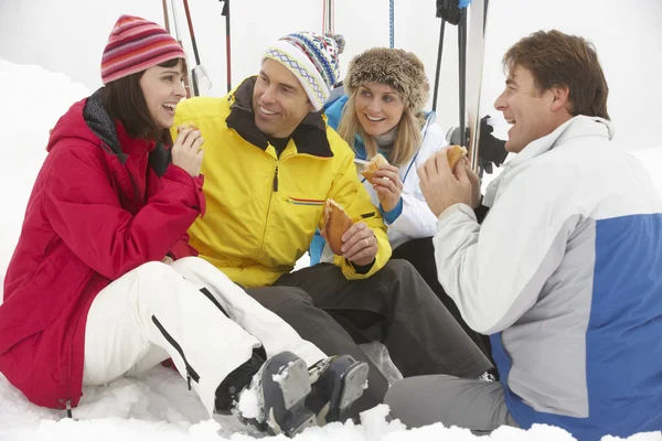 Grupo de amigos de mediana edad comiendo sándwich en vacaciones de esquí en M —  Fotos de Stock