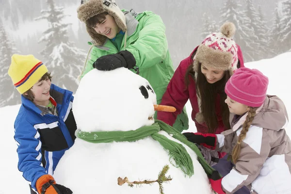 Ομάδα παιδιών με βάση χιονάνθρωπος διακοπές σκι στα βουνά — Φωτογραφία Αρχείου