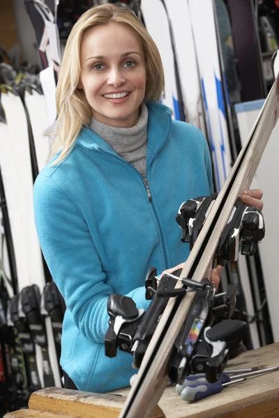 与滑雪板在租用店里的女销售助理 — 图库照片