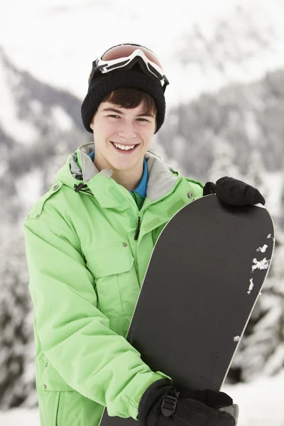 Nastoletni chłopiec z snowboardu na narty w góry — Zdjęcie stockowe