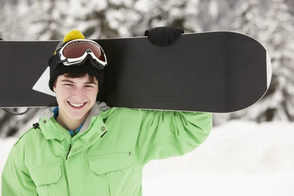 Мальчик-подросток со сноубордом на лыжном отдыхе в горах — стоковое фото