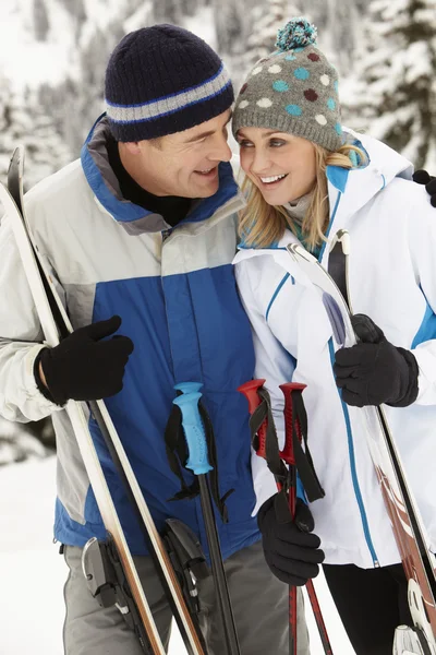 Medelålders par på skidsemester i bergen — Stockfoto