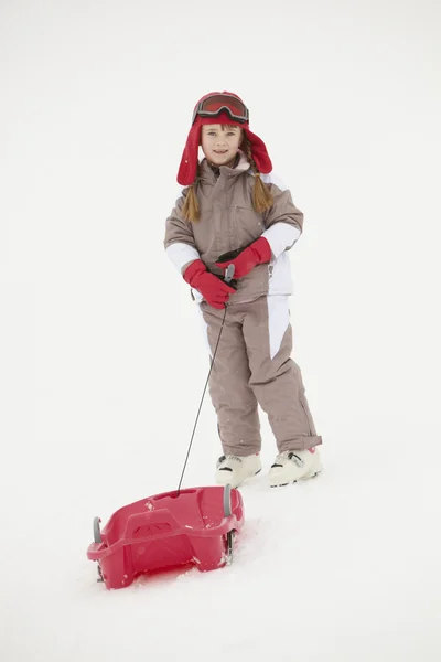 Menina Puxando Sledge em férias de esqui em montanhas — Fotografia de Stock