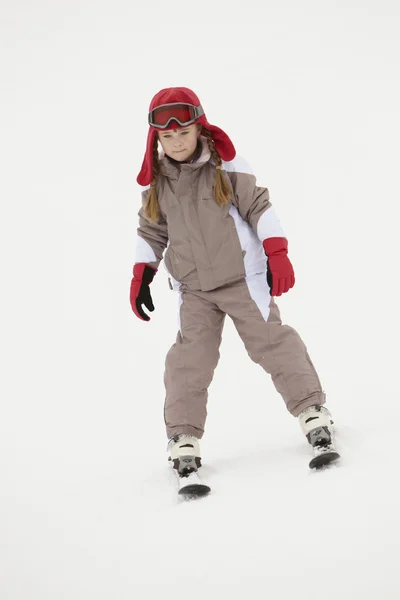 Mladá dívka na dovolené v horách lyžování po svahu — Stock fotografie