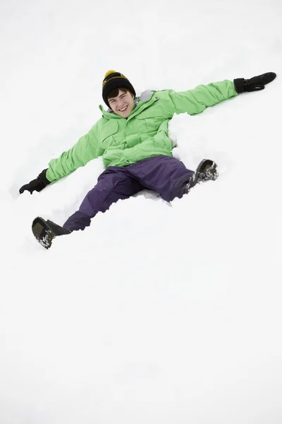 Genç çocuk kar melek yamaçta yapma — Stok fotoğraf