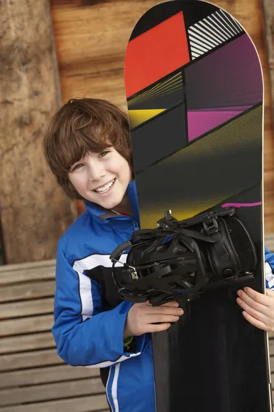 Fiú, a Snowboard, a sí ünnep előtt fából készült háttér — Stock Fotó