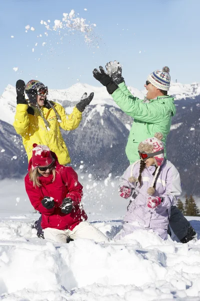 Família adolescente tendo luta de neve nas montanhas — Fotografia de Stock