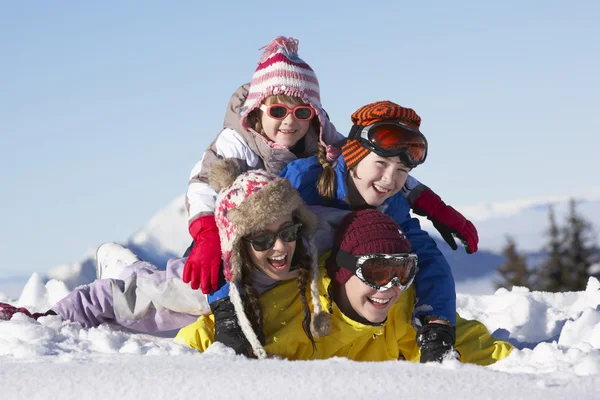 Група дітей розважаються на лижному відпочинку в горах — стокове фото