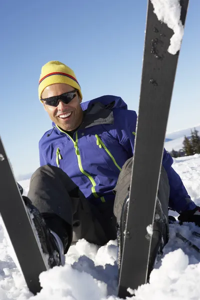 Hombre esquiador sentado en la nieve con después de la caída —  Fotos de Stock