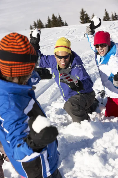 Família tendo bola de neve luta em férias de esqui em montanhas — Fotografia de Stock