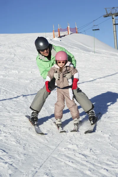 父亲教女儿在山中虽然在度假滑雪 — 图库照片