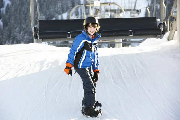 Jovem menino saindo cadeira elevador no esqui férias em montanhas — Fotografia de Stock