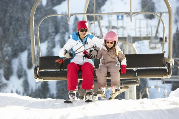 Madre e hija bajándose de la silla de elevación en vacaciones de esquí en Mou — Foto de Stock