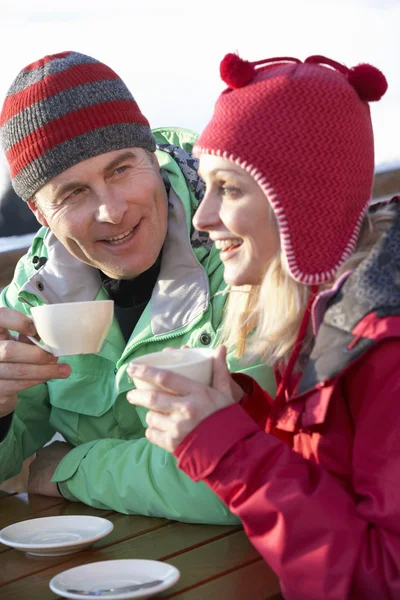Couple bénéficiant d'une boisson chaude dans le café à la station de ski — Photo