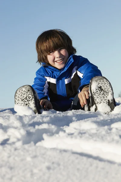 Genç çocuk karda tatil dağlarında oynuyor. — Stok fotoğraf