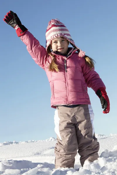 Genç kız karda tatil dağlarında oynuyor. — Stok fotoğraf