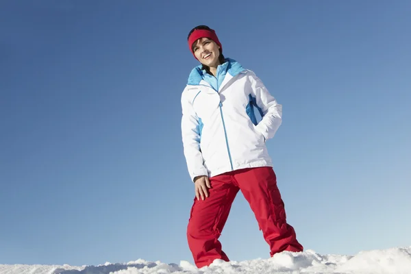 Femme debout dans la neige portant des vêtements chauds pendant les vacances de ski en Mo — Photo