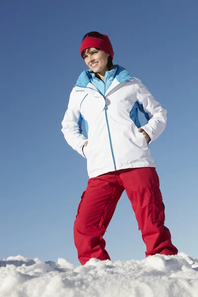 Mulher de pé na neve vestindo roupas quentes em férias de esqui em Mo — Fotografia de Stock