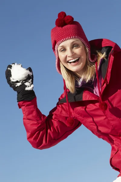Mujer a punto de lanzar bola de nieve con ropa abrigada en esquí Holida —  Fotos de Stock