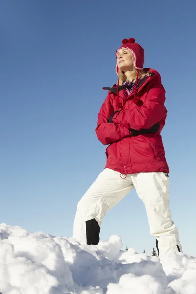 Γυναίκα να στέκεται στα χιόνια φορώντας ζεστά ρούχα για διακοπές σκι στο mo — Φωτογραφία Αρχείου
